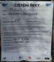 Banner s informacemi na břehu řeky.